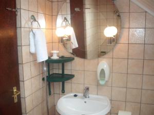 bagno con lavandino, specchio e orinatoio di Nimród Pihenőház a Egerszalók Altre 29 foto