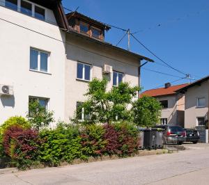 an apartment building on a street with trees and bushes at Apartment Ksenija in Ljubljana