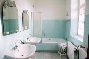 a bathroom with two sinks and a bath tub at Chambres d'hôtes de charme Le Pradel in Monceaux-sur-Dordogne