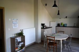 a kitchen with a table and chairs and a kitchen with a refrigerator at B&B Dujardin in Dilbeek