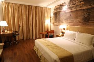 a hotel room with a bed and a stone wall at Regenta Central RS Chennai OMR SIPCOT in Chennai