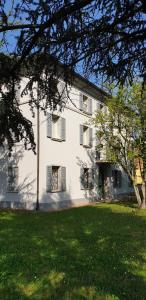 a large white building with a green lawn in front of it at Hotel Sporting in Campagnola Emilia