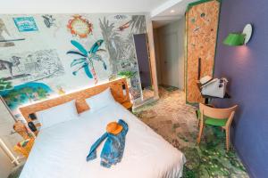 een slaapkamer met een bed en een muur met een muurschildering bij ibis Styles Paris Boulogne Marcel Sembat in Boulogne-Billancourt