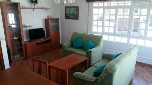 a living room with two chairs and a table and a television at Insua in Laxe