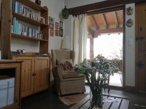 un salon avec une chaise et un vase de fleurs dans l'établissement El MIRADOR DE TONO , Casa entera, à Vioño