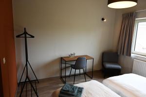 Cette chambre comprend un bureau, une table et une chaise. dans l'établissement B&B Dujardin, à Dilbeek