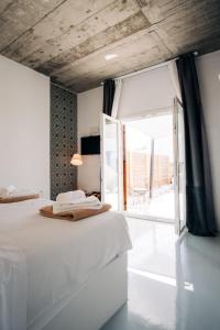 a bedroom with a bed and a large window at Mesanto Luxury Suites in Megalokhori