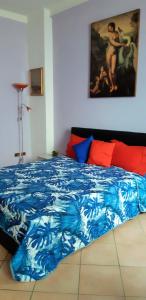 a bedroom with a blue bed with a painting on the wall at L'opera al Teatro Romano di Verona in Verona