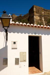 un bâtiment blanc avec une porte et un téléphone à péage dans l'établissement Casas de Mértola 33, à Mértola