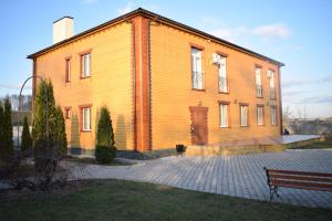 un gran edificio de madera con un banco delante de él en Fermerska Hata en Dubno