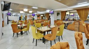 uma sala de jantar com mesas e cadeiras amarelas em AZIMUT Hotel Penza em Penza