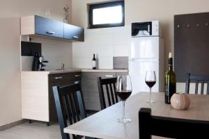 una cucina con tavolo e 2 bicchieri di vino di Dunazug Apartmanház a Dömös