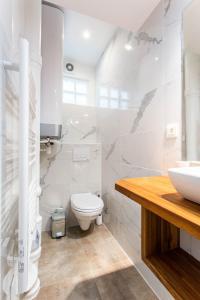 a white bathroom with a toilet and a sink at CMG Oberkampf/ Charonne C in Paris