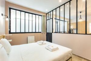 a bedroom with a bed with two towels on it at CMG Oberkampf/ Charonne C in Paris