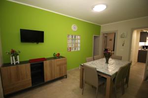 ein Wohnzimmer mit einem Tisch und einer grünen Wand in der Unterkunft Porte Maqueda in Palermo