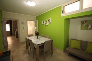 een eetkamer met groene muren en een tafel en stoelen bij Porte Maqueda in Palermo +2 foto's