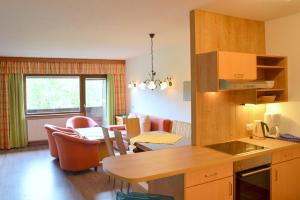 cocina y sala de estar con mesa y sillas en Ferienwohnungen Greiderer Walchsee, en Walchsee