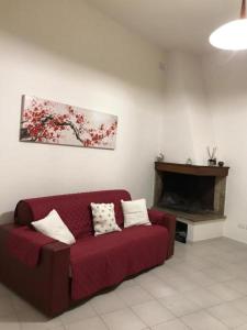 ein Wohnzimmer mit einem roten Sofa und einem Kamin in der Unterkunft Laura's house in Cagliari