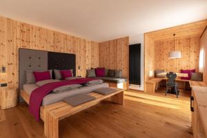 a bedroom with a large bed and wooden walls at Garnì Lilly in San Lorenzo in Banale