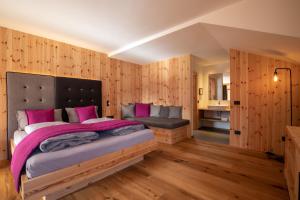 a bedroom with a large bed with pink sheets at Garnì Lilly in San Lorenzo in Banale