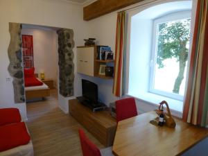 a living room with a dining room table and a window at Ferienwohnung Lienz Egger in Lienz