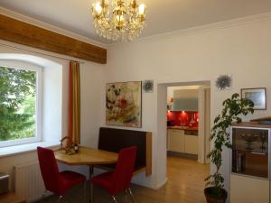 Ferienwohnung Lienz Egger في لينز: غرفة طعام مع طاولة وكراسي حمراء
