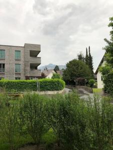 a view of a building with bushes and trees at Kleines Nest im Zentrum, eigener Eingang, Parkplatz, kostenloses Wlan in Dornbirn