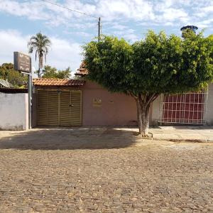 a tree in front of a building with a garage at Pouso in Pirenópolis