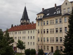Un gran edificio con una torre de reloj en la parte superior. en AA-Apartment -7 Wohnungen für Geschäftsreisende - wie zu Hause, en Chemnitz