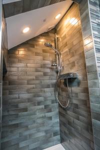 a shower in a bathroom with a stone wall at Arthur's Bar & Accommodation in Southport