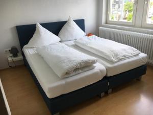 2 camas con sábanas blancas y almohadas en Landhaus Wiesemann Parkappartements & Dependance - Nähe Ettelsberg-Talstation, en Willingen