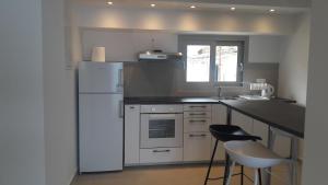 a kitchen with a white refrigerator and a counter at Villa Elsi upper apartment in Kalami