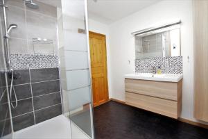 a bathroom with a shower and a sink and a mirror at Chalet du Pre in Séez