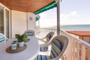 - une table et des chaises blanches sur un balcon donnant sur l'océan dans l'établissement Homes&Go Bell Racó Confort III, à La Pineda
