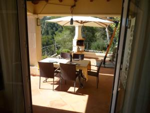 a table and chairs with an umbrella on a patio at Traumvilla Encina in Canyamel