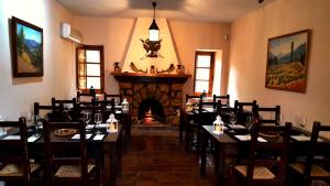 a dining room with tables and a fireplace at Casa Rural Los Parrales in El Tranco