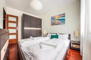 1 dormitorio con 1 cama grande con sábanas blancas en Apartamenty Sun&Snow Marina Primore en Gdansk