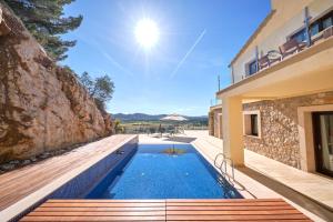une maison avec une piscine à côté d'un bâtiment dans l'établissement Villa Diamond by Cap Vermell Estate, à Canyamel