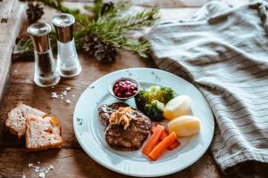 a plate of food with meat and vegetables on a table at Venabu Fjellhotell in Venabygd +43 photos