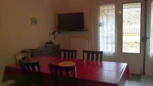 a dining room with a table with chairs and a television at Le Preia in Prez-sur-Marne