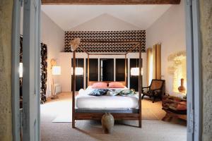 a bedroom with a canopy bed with pink pillows at La Bastide du Farfadet in Laudun