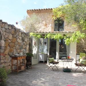 a patio with chairs and a stone wall at Casa Jasmin at Masia Nur Sitges, Adults only in Canyelles