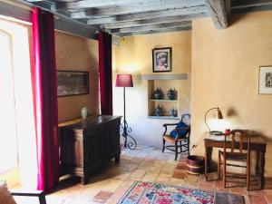 Zimmer mit einem Schreibtisch, einer Lampe und einem Tisch in der Unterkunft La Bastide du Farfadet in Laudun