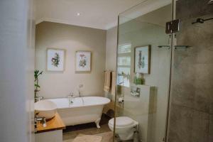 a bathroom with a tub and a toilet and a shower at Franschhoek Village House in Franschhoek +55 photos