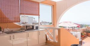 une cuisine avec un four micro-ondes sur un plan de travail et un balcon dans l'établissement Ocean View I (San Eugenio Alto), à Adeje