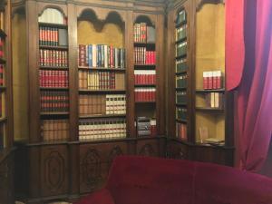 a library with wooden book shelves filled with books at Palazzo Laguardia in Fasano