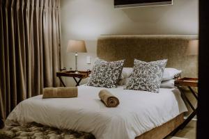 a bedroom with a large bed with white sheets and pillows at Franschhoek Village House in Franschhoek