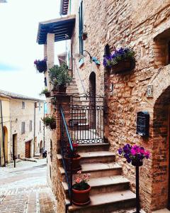 a stone building with stairs and flowers on it at Domus Flora Guest House in Spello