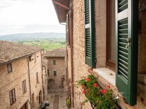 Una vista desde una ventana abierta en un pueblo italiano. en Domus Flora Guest House, en Spello