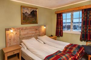 1 dormitorio con cama y ventana en Venabu Fjellhotell, en Venabygd